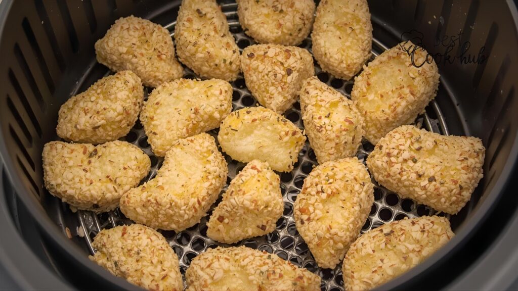 Bestcookhub - Breaded cheese curds arranged in air fryer basket ready to cook