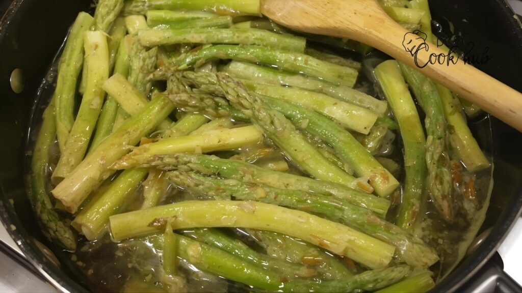 Bestcookhub - Frozen asparagus sautéing in a skillet with garlic and seasoning