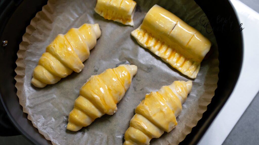 Bestcookhub - Golden brown egg rolls in an air fryer basket