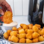 Bestcookhub - Golden fried cheese curds served with dipping sauce next to air fryer