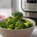 Bestcookhub - Steamed broccoli in a bowl with Instant Pot in the background